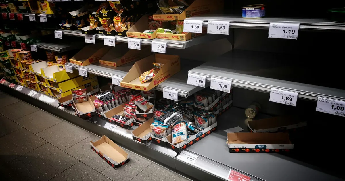 A view of partially empty supermarket shelves indicating high consumer demand or supply issues.