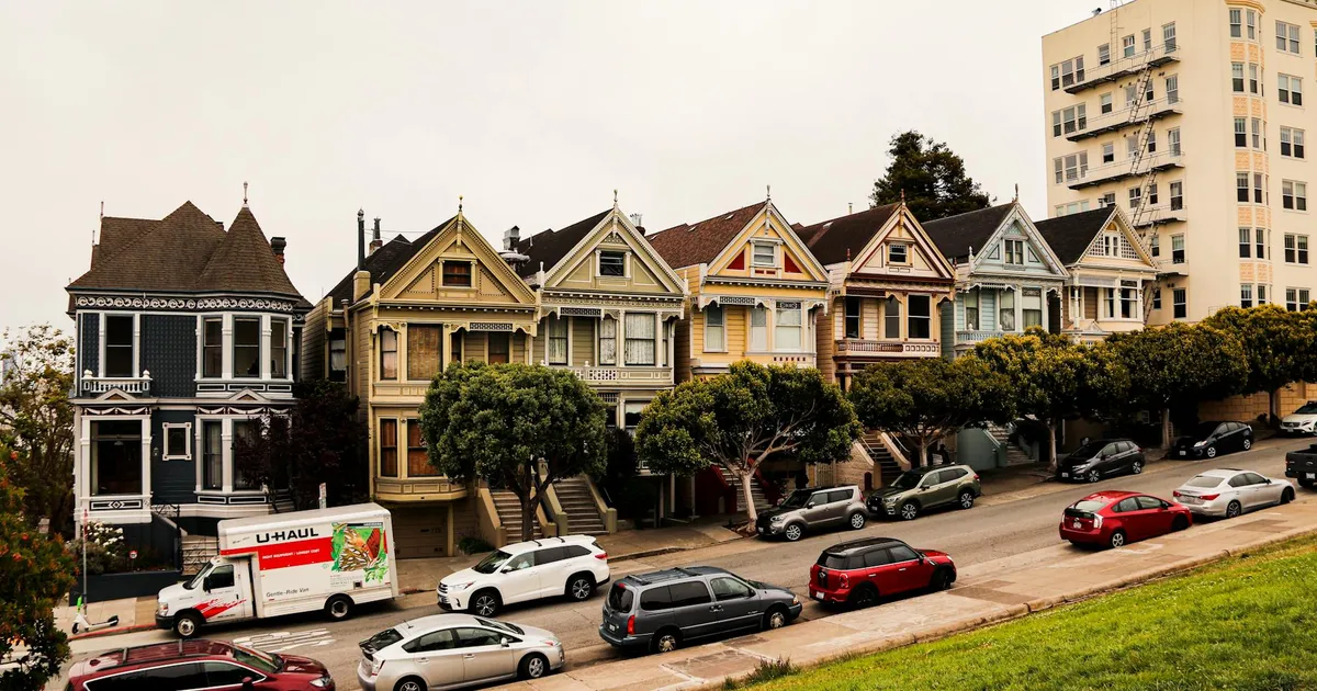 Historic Painted Ladies homes with parked cars in San Francisco, showcasing Victorian architecture.