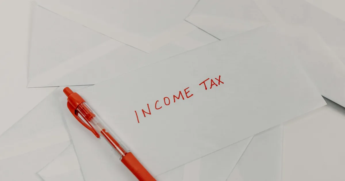Studio shot of income tax envelope with red pen for accounting and tax season preparation.
