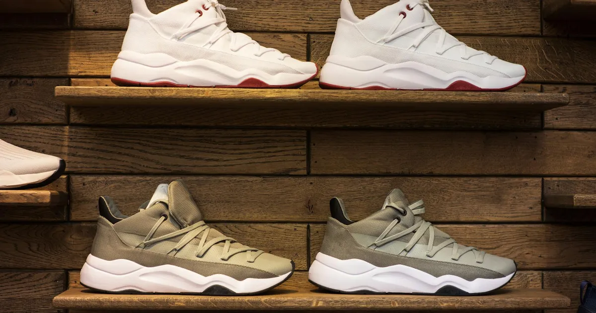 Modern sneakers showcased on wooden shelves in a stylish display setting.