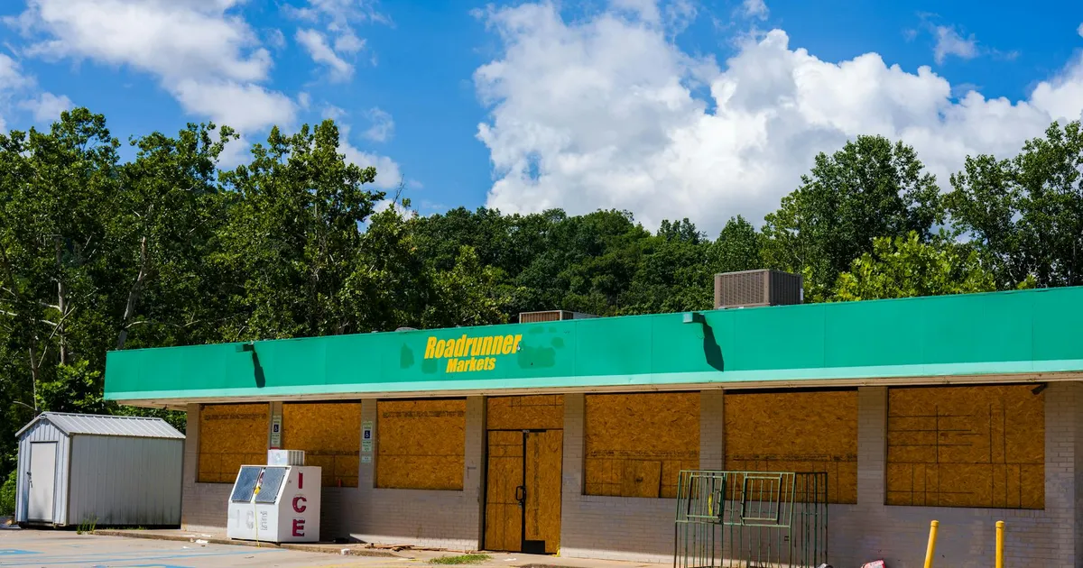 Image of an abandoned Roadrunner Markets store with boarded windows.